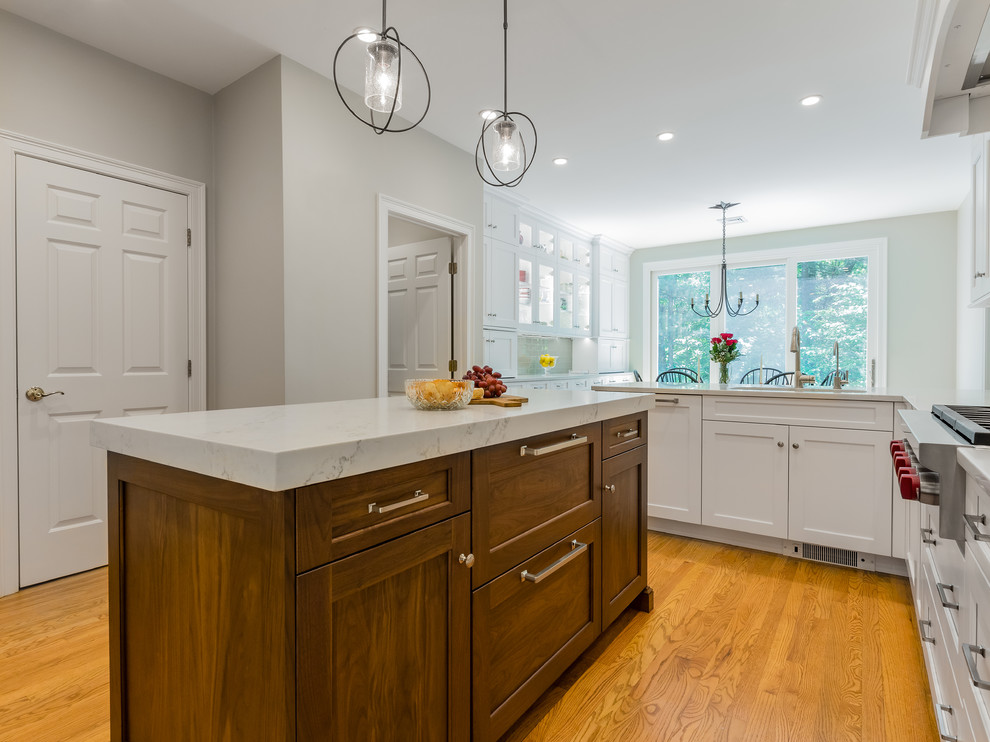 Example of a transitional u-shaped eat-in kitchen design in Providence with an undermount sink, white cabinets, quartzite countertops, glass tile backsplash, stainless steel appliances and an island