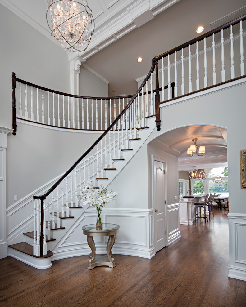 This is an example of a mid-sized wood curved staircase in New York with wood risers, wood railing and panelled walls.