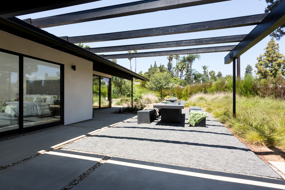 Large midcentury one-storey white house exterior in Orange County with a gable roof and a shingle roof.