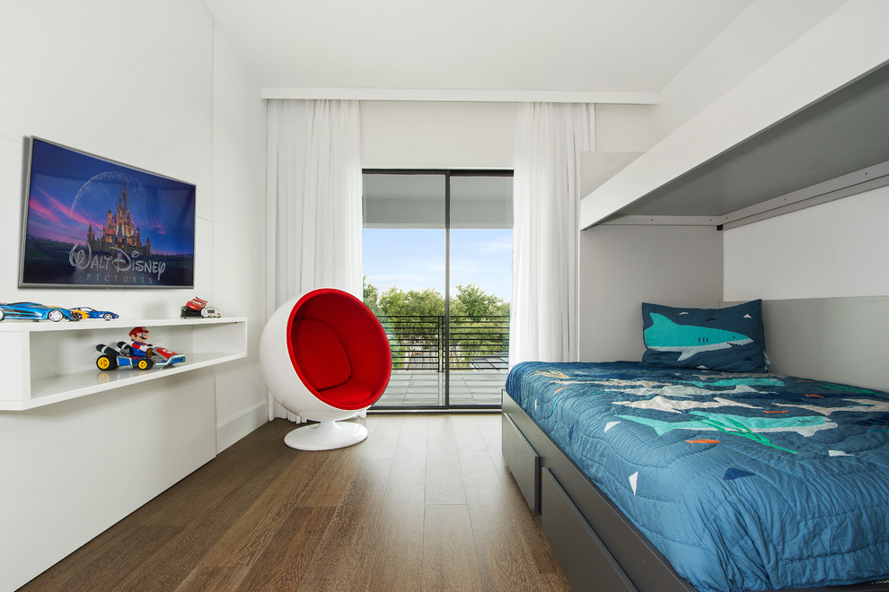 This is an example of a contemporary kids' bedroom for kids 4-10 years old and boys in Orlando with white walls, medium hardwood floors and brown floor.