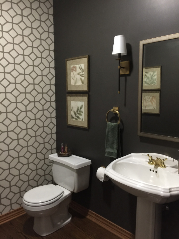 Inspiration for a small traditional cloakroom in Wichita with a two-piece toilet, brown walls, dark hardwood flooring, a pedestal sink, brown floors, a feature wall and wallpapered walls.