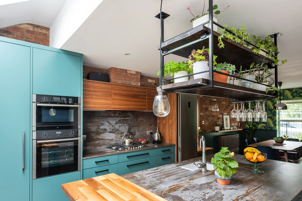 Photo of a mid-sized contemporary galley eat-in kitchen in Other with a drop-in sink, flat-panel cabinets, turquoise cabinets, quartzite benchtops, metallic splashback, slate splashback, stainless steel appliances, porcelain floors, with island, white floor and multi-coloured benchtop.
