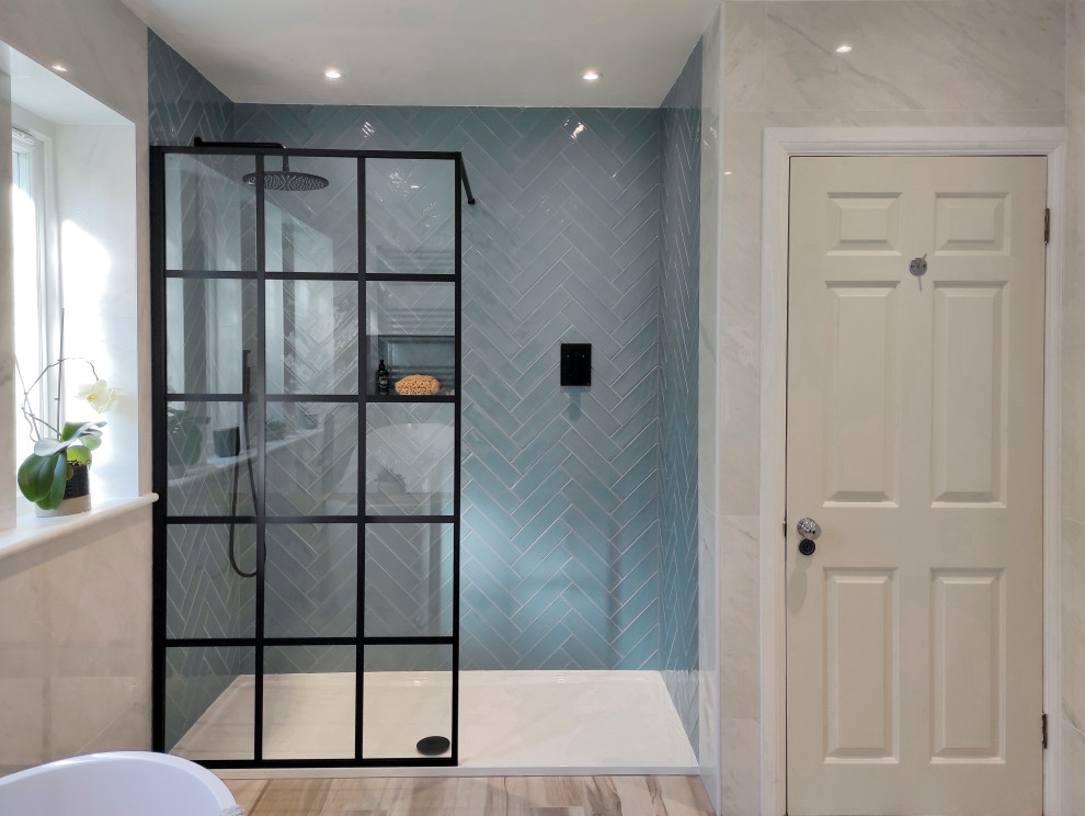 Design ideas for a large modern kids bathroom in London with black cabinets, a freestanding tub, an open shower, blue tile, ceramic tile, porcelain floors, granite benchtops, black benchtops, a double vanity and a built-in vanity.