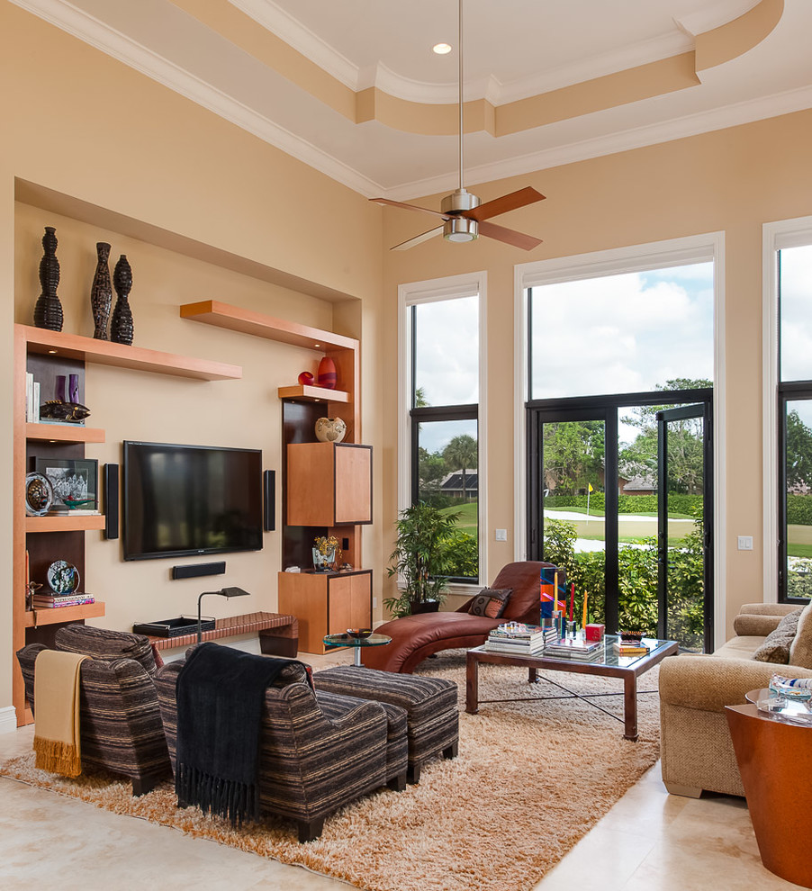 Photo of a large transitional open concept family room in Miami with beige walls, travertine floors, a wall-mounted tv and beige floor.