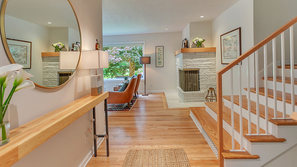 This is an example of a mid-sized midcentury foyer in Portland with grey walls, light hardwood floors, a single front door and a light wood front door.