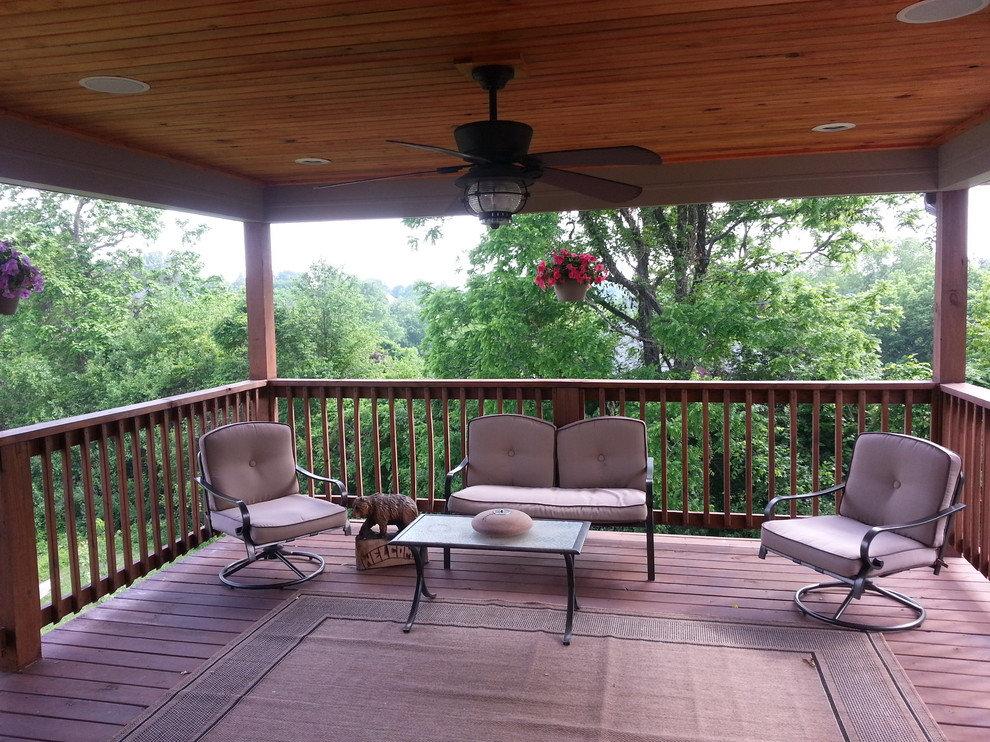 Large traditional backyard deck in Louisville with a roof extension.