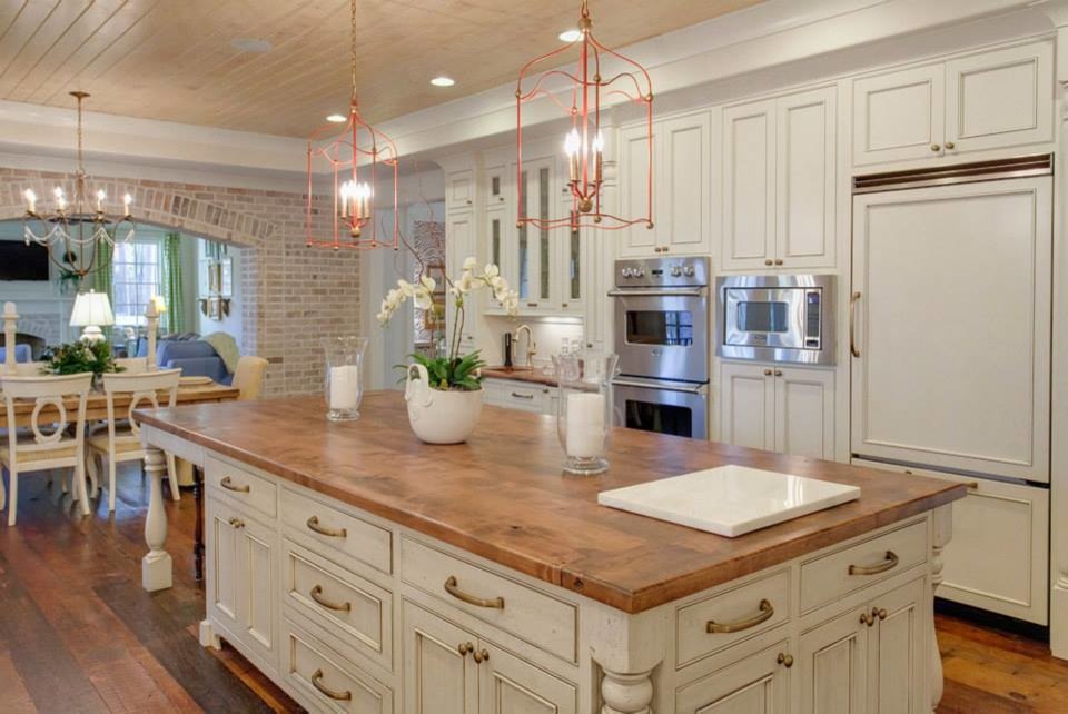 Transitional l-shaped eat-in kitchen in Raleigh with white cabinets and white splashback.