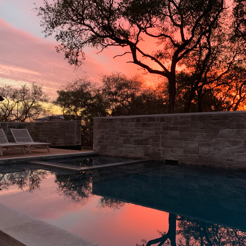 Modern courtyard rectangular pool in Austin with a hot tub and decking.