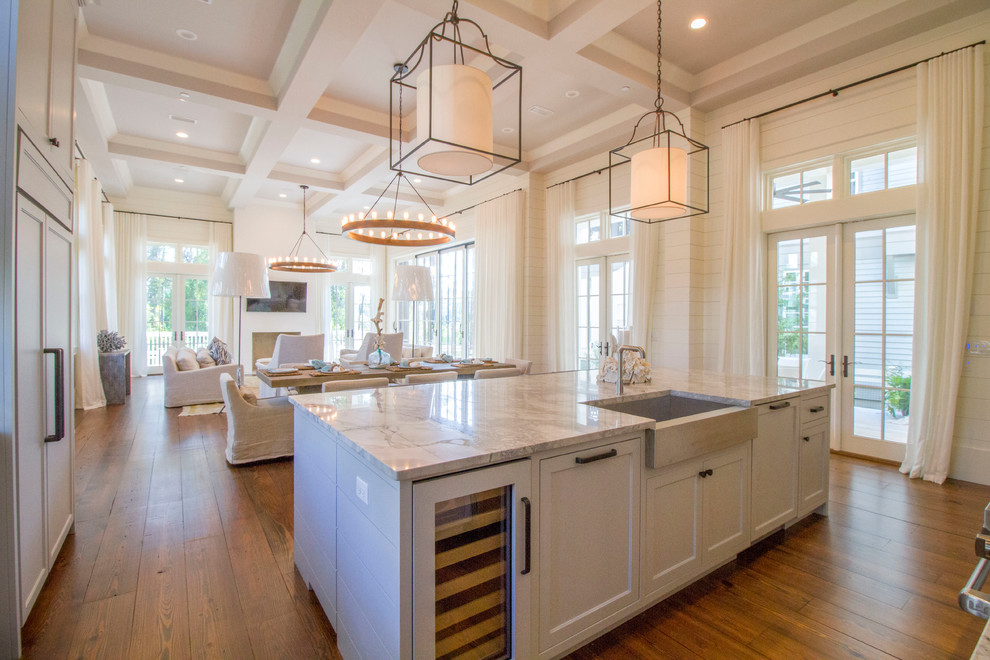 Inspiration for a beach style l-shaped open plan kitchen in Miami with a farmhouse sink, shaker cabinets, white cabinets, dark hardwood floors and with island.