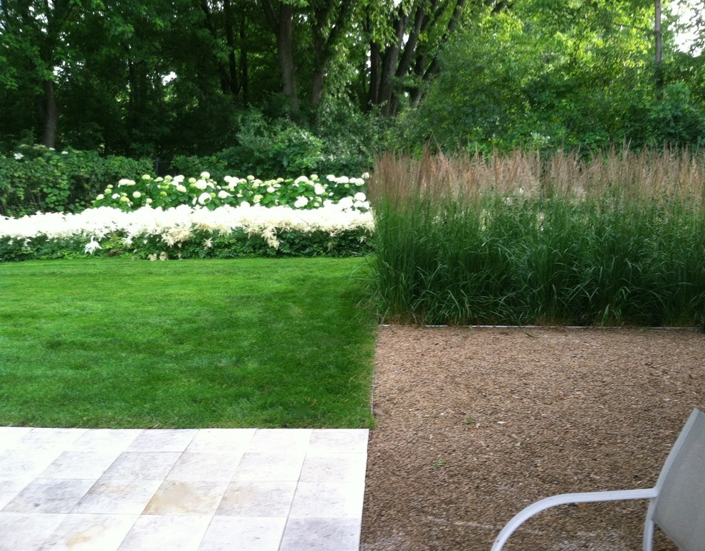 This is an example of a mid-sized modern backyard partial sun formal garden for summer in Minneapolis with a garden path and natural stone pavers.
