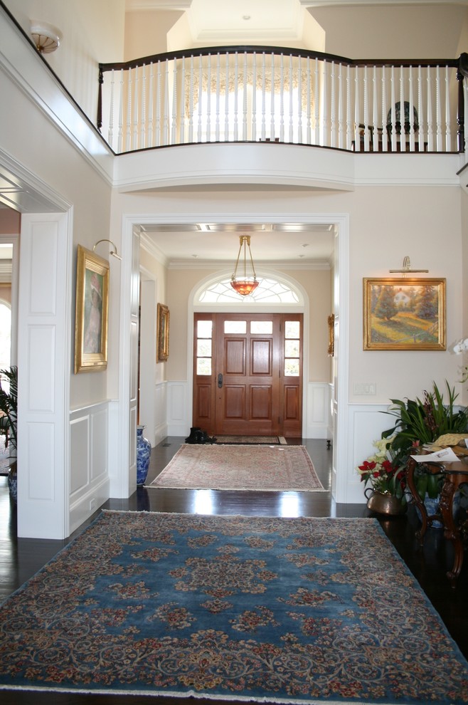 Photo of a mid-sized traditional foyer in Boston with pink walls, dark hardwood floors, a single front door and a dark wood front door.
