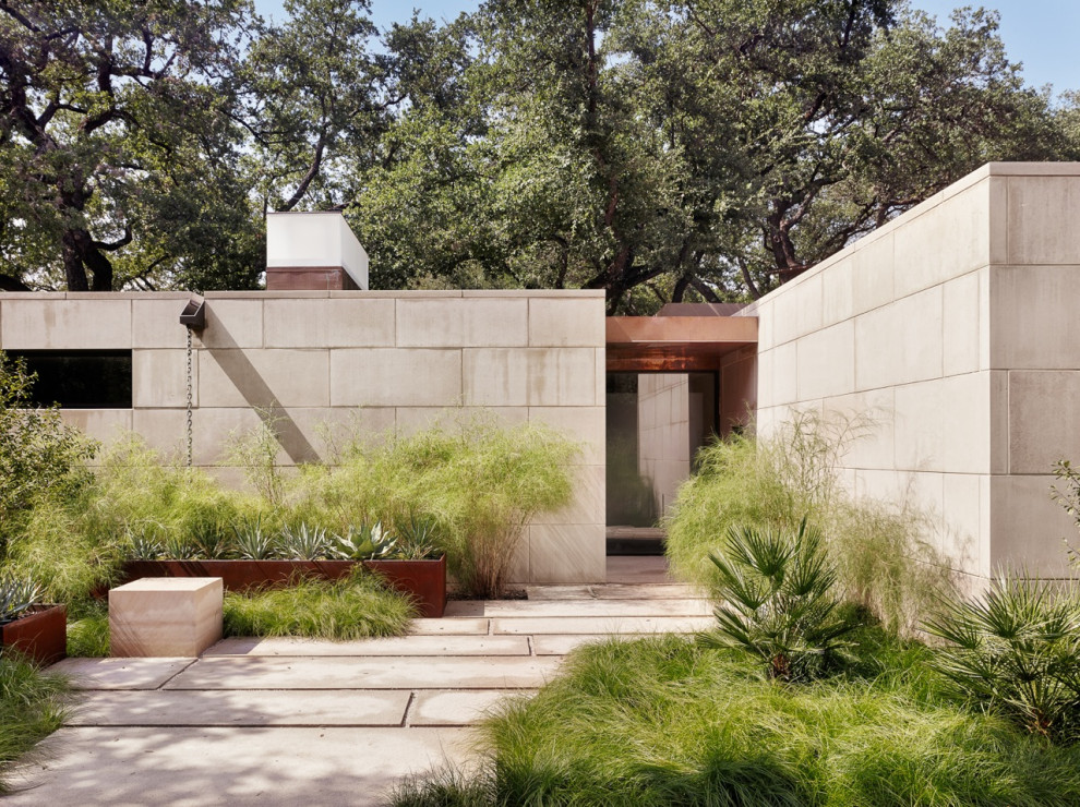Photo of a large modern one-storey beige house exterior in Austin with stone veneer and a flat roof.