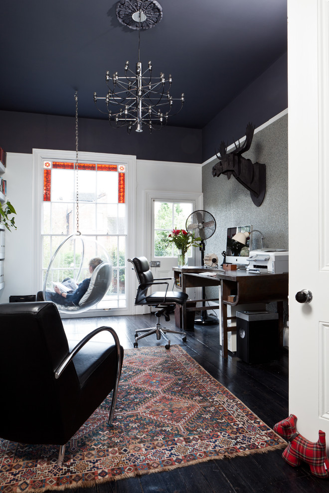 Inspiration for a transitional home office in Birmingham with black walls, a freestanding desk and black floor.