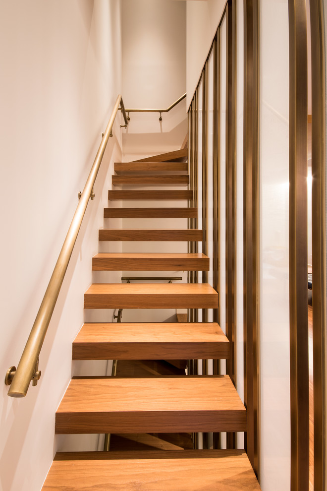 This is an example of a contemporary wood l-shaped staircase in New York with open risers and metal railing.