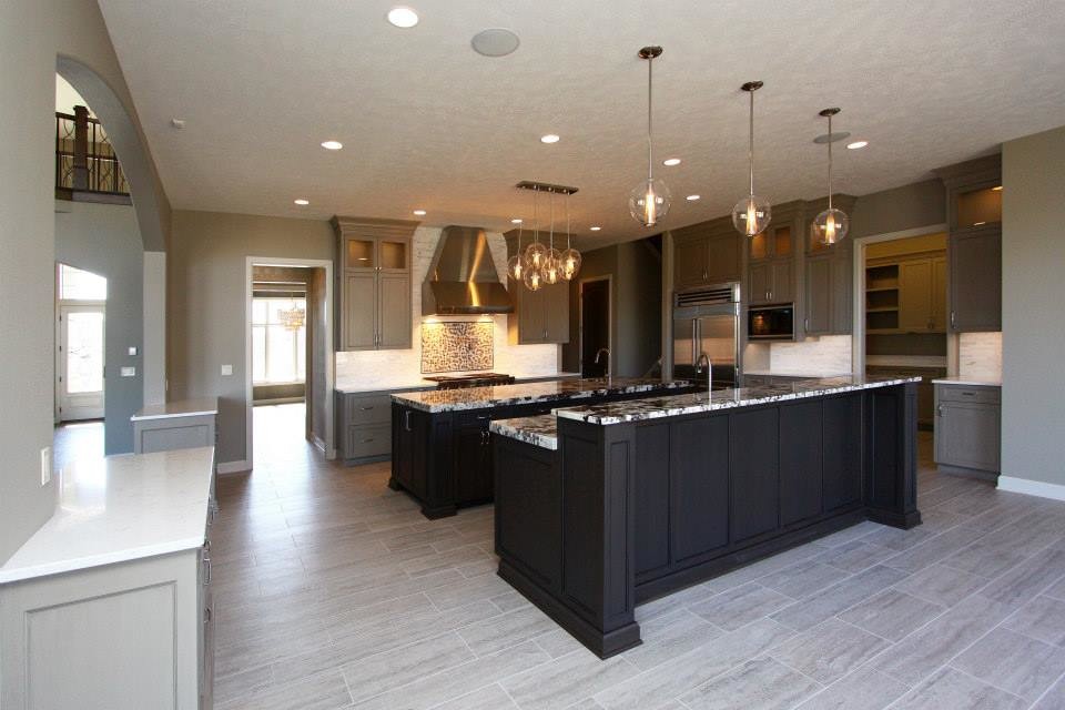 Inspiration for a huge ceramic tile kitchen remodel with an undermount sink, recessed-panel cabinets, gray cabinets, granite countertops, white backsplash, porcelain backsplash, stainless steel appliances and two islands
