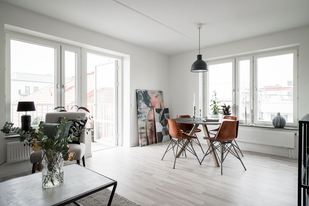 This is an example of a scandinavian dining room in Gothenburg with white walls and white floor.