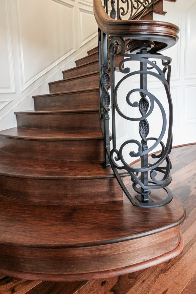This is an example of a large eclectic wood curved staircase in DC Metro with wood risers and mixed railing.