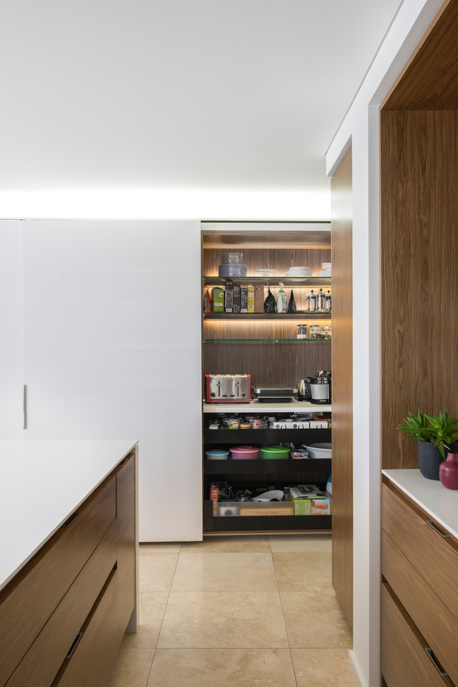 Design ideas for a mid-sized modern l-shaped open plan kitchen in Sydney with a double-bowl sink, flat-panel cabinets, medium wood cabinets, solid surface benchtops, white splashback, glass sheet splashback, stainless steel appliances, limestone floors, with island and beige floor.