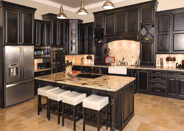 Inspiration for a mid-sized transitional l-shaped separate kitchen in Chicago with a farmhouse sink, raised-panel cabinets, black cabinets, granite benchtops, beige splashback, stone tile splashback, stainless steel appliances, travertine floors and with island.