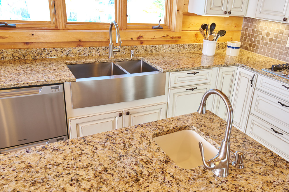Example of a l-shaped eat-in kitchen design with a farmhouse sink, granite countertops, ceramic backsplash, stainless steel appliances and an island