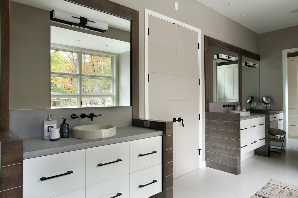 Inspiration for a large transitional master bathroom in Grand Rapids with a vessel sink, flat-panel cabinets, white cabinets, concrete benchtops, a drop-in tub, a corner shower, a one-piece toilet, white tile, ceramic tile, grey walls and ceramic floors.