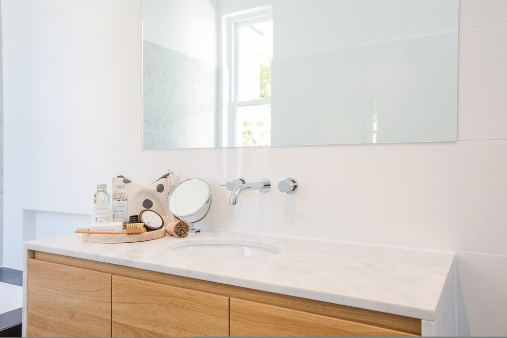 Mid-sized contemporary 3/4 bathroom in Adelaide with white tile, ceramic tile, white walls, porcelain floors, quartzite benchtops, brown floor, furniture-like cabinets, light wood cabinets and white benchtops.