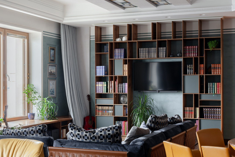 Foto de biblioteca en casa gris y blanca contemporánea grande con paredes grises, suelo de madera en tonos medios y televisor colgado en la pared