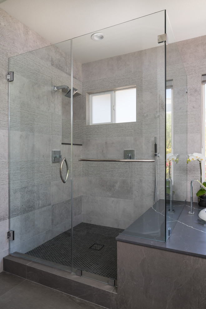 Design ideas for a large contemporary master bathroom in Los Angeles with raised-panel cabinets, grey cabinets, a drop-in tub, a corner shower, a one-piece toilet, gray tile, porcelain tile, white walls, porcelain floors, an undermount sink, engineered quartz benchtops, black floor, a hinged shower door, black benchtops, a shower seat, a double vanity and a built-in vanity.