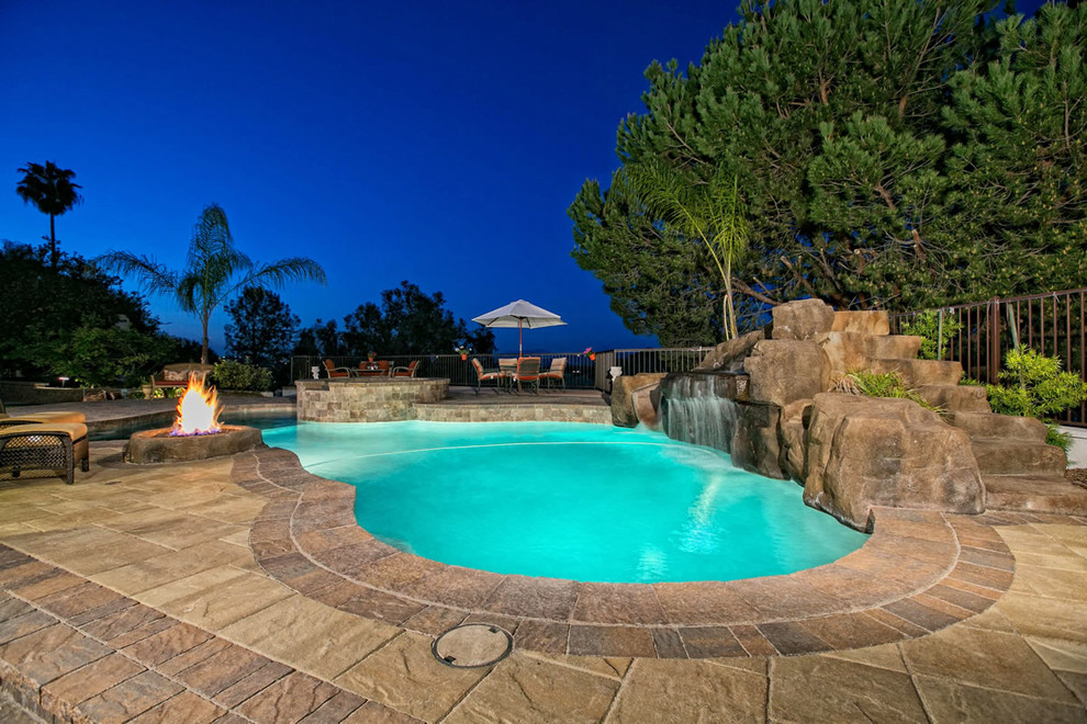 Design ideas for an expansive backyard custom-shaped natural pool in San Diego with concrete pavers.