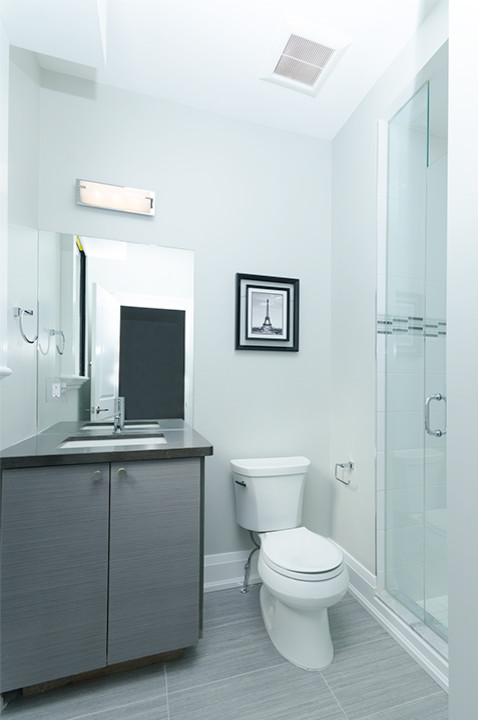 Design ideas for a small contemporary bathroom in Toronto with an undermount sink, flat-panel cabinets, a two-piece toilet, gray tile and marble floors.