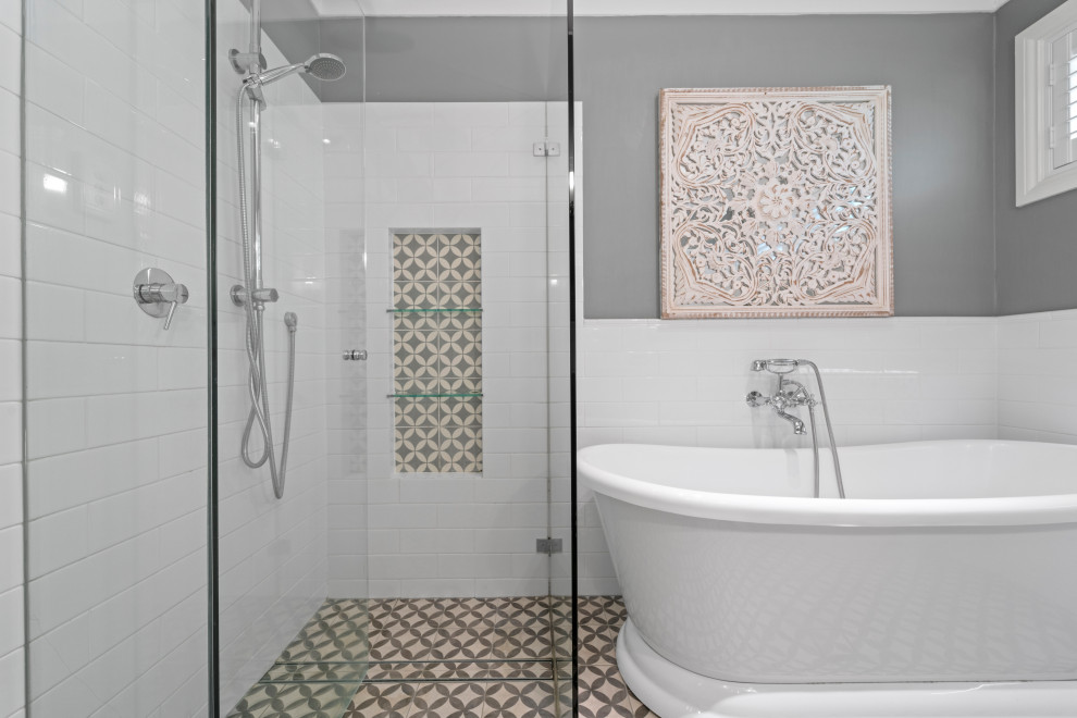 Inspiration for a mid-sized traditional master bathroom in Sydney with shaker cabinets, white cabinets, a freestanding tub, a corner shower, a one-piece toilet, white tile, ceramic tile, grey walls, cement tiles, marble benchtops, multi-coloured floor, a hinged shower door, white benchtops, a niche, a single vanity and a freestanding vanity.