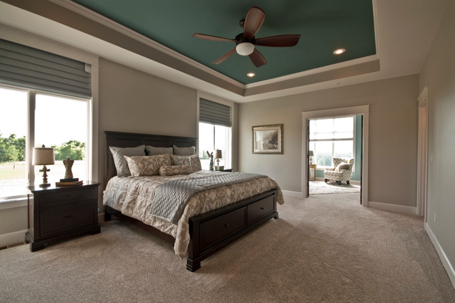 Large contemporary master bedroom in Other with carpet.