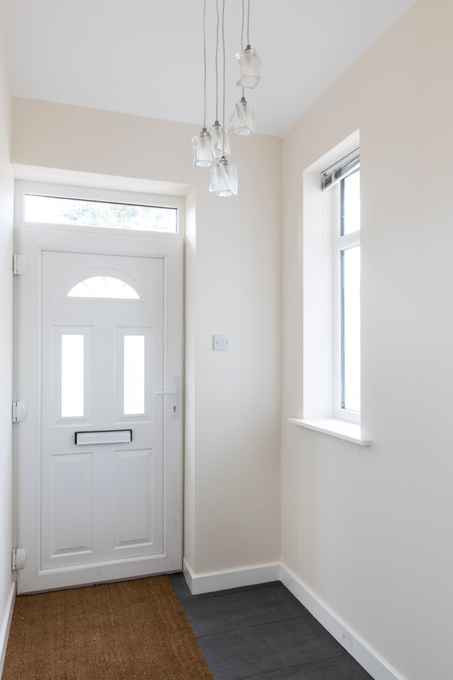 Photo of a small modern vestibule in London with beige walls, ceramic floors, a single front door, a white front door and grey floor.