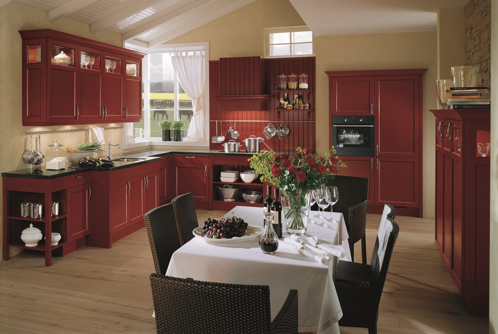 Country separate kitchen in London with red cabinets.