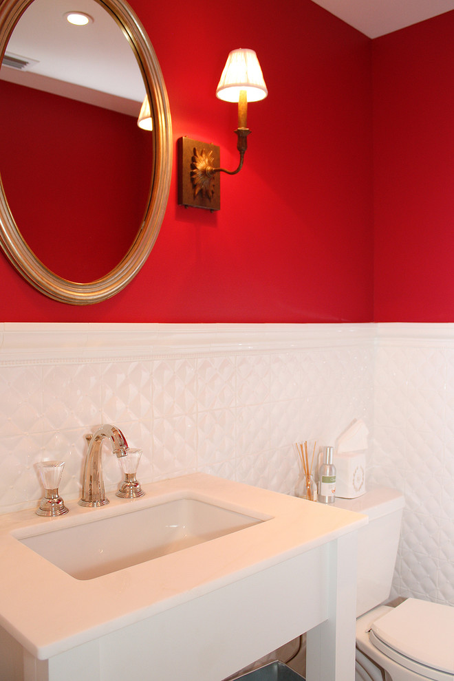 Inspiration for a large beach style powder room in Tampa with white cabinets, a one-piece toilet, white tile, ceramic tile, red walls, an integrated sink and engineered quartz benchtops.