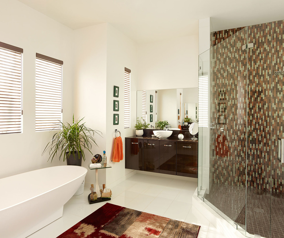 Photo of a mid-sized contemporary master bathroom in Charleston with dark wood cabinets, a freestanding tub, a corner shower, multi-coloured tile, mosaic tile, white walls, ceramic floors, a vessel sink, flat-panel cabinets, wood benchtops, white floor, a hinged shower door and multi-coloured benchtops.