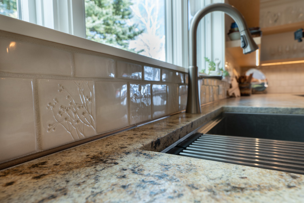 Eat-in kitchen - mid-sized transitional u-shaped vaulted ceiling eat-in kitchen idea with shaker cabinets, green cabinets, granite countertops, beige backsplash, ceramic backsplash, stainless steel appliances, an island and multicolored countertops