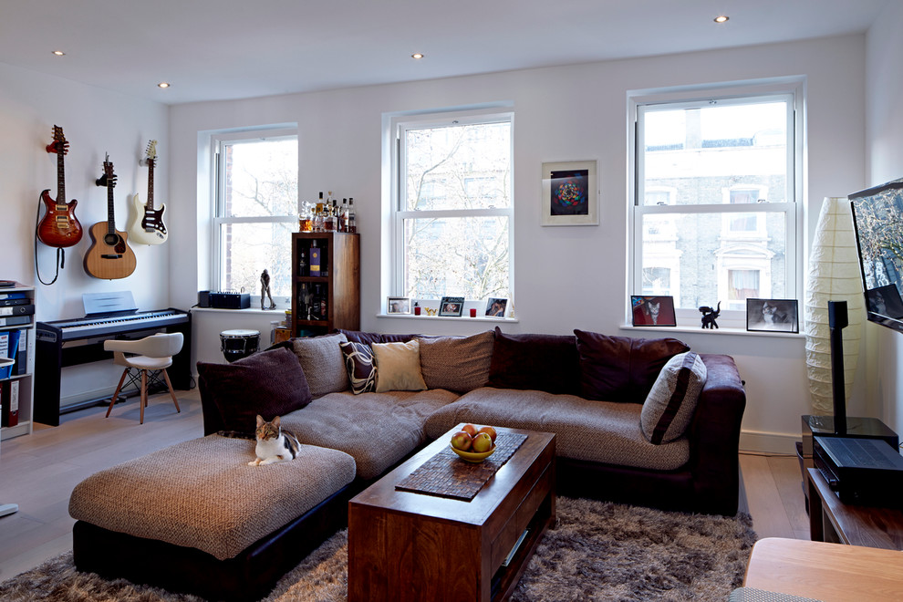 Design ideas for a large contemporary living room in London with light hardwood floors.