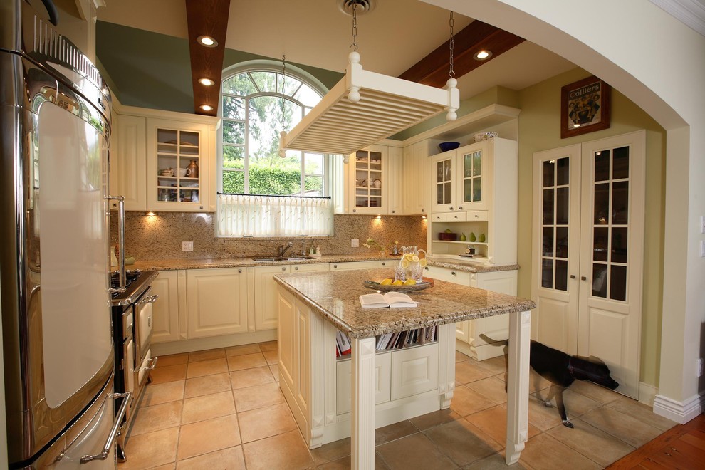 This is an example of a mediterranean kitchen in Vancouver with glass-front cabinets.