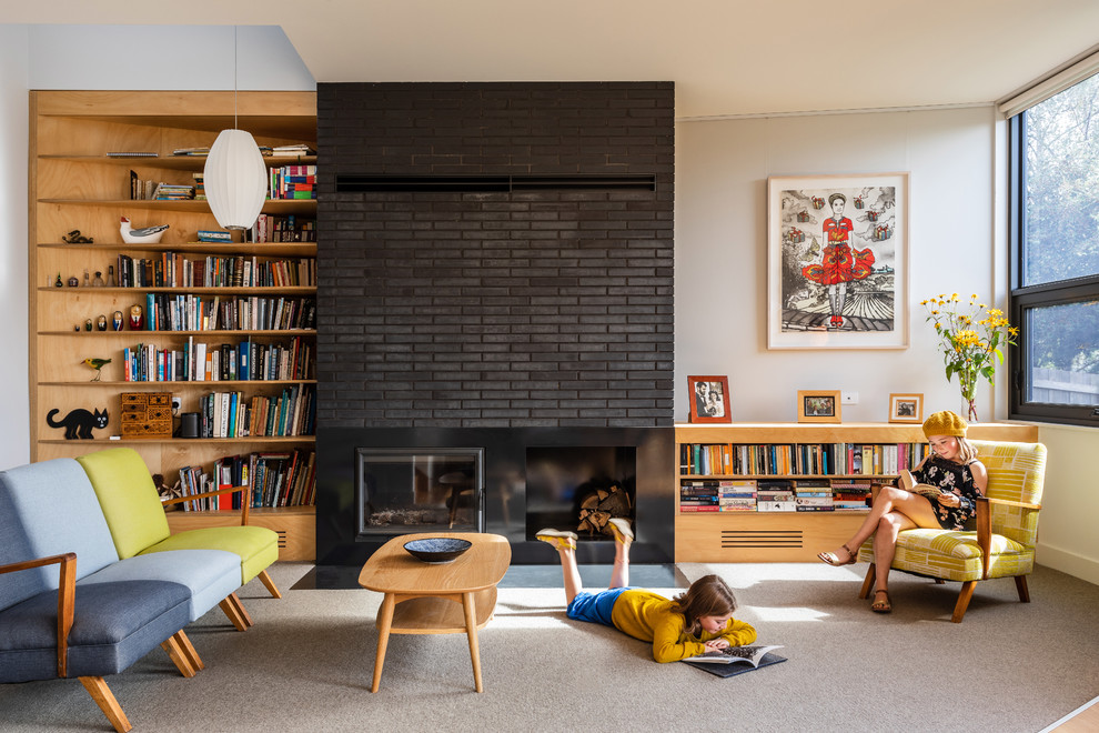 Inspiration for a midcentury living room in Hobart with white walls, carpet, a standard fireplace, a brick fireplace surround and beige floor.