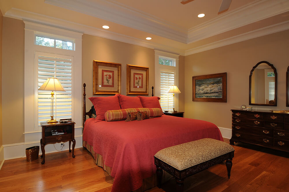 This is an example of a mid-sized traditional guest bedroom in Orange County with no fireplace, beige walls, dark hardwood floors and brown floor.