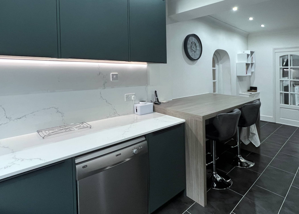 Inspiration for a small contemporary enclosed kitchen in London with flat-panel cabinets, green cabinets, stainless steel appliances, grey floors and white worktops.