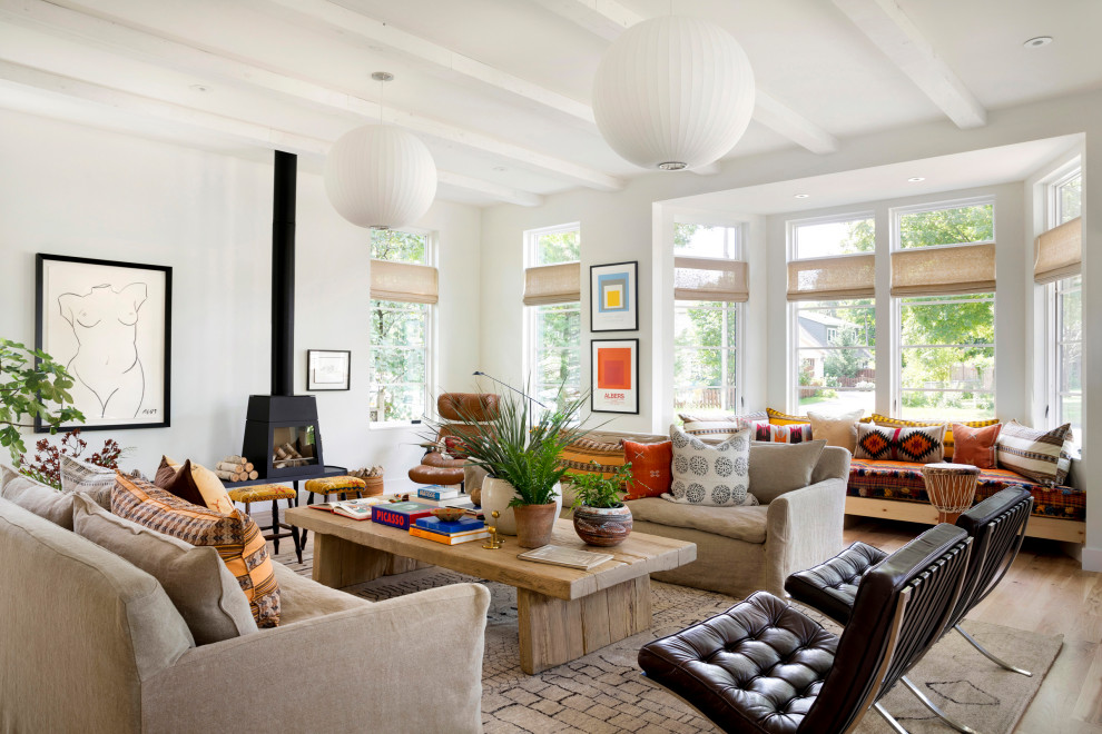 Mid-sized eclectic open concept living room in Minneapolis with white walls, light hardwood floors, a wood stove and no tv.