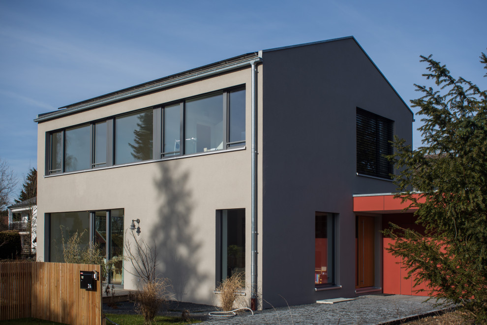 Zweistöckiges Modernes Einfamilienhaus mit Putzfassade, grauer Fassadenfarbe, Satteldach, Ziegeldach und grauem Dach in München