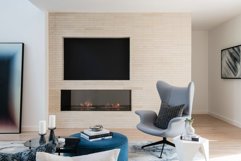 Photo of a mid-sized contemporary open concept living room in Austin with white walls, medium hardwood floors, a two-sided fireplace, a brick fireplace surround and a built-in media wall.
