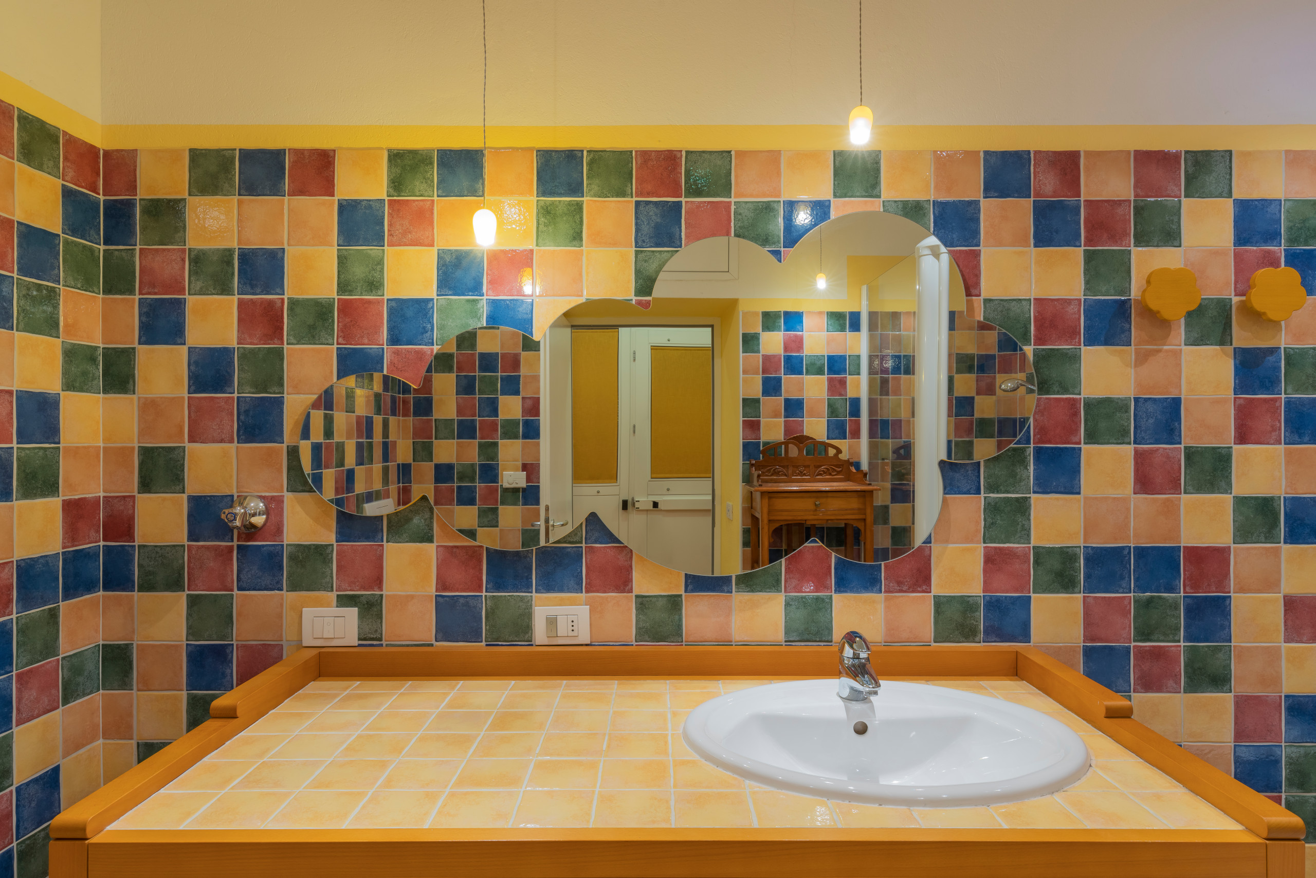 Idee per una stanza da bagno con doccia rustica di medie dimensioni con WC sospeso, piastrelle multicolore, piastrelle in ceramica, pareti gialle, pavimento con piastrelle in ceramica, lavabo sospeso,