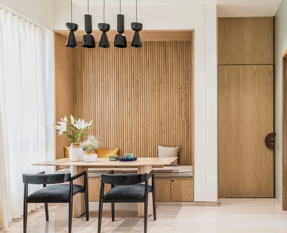 Contemporary dining room in Mumbai with white walls, beige floor and wood walls.