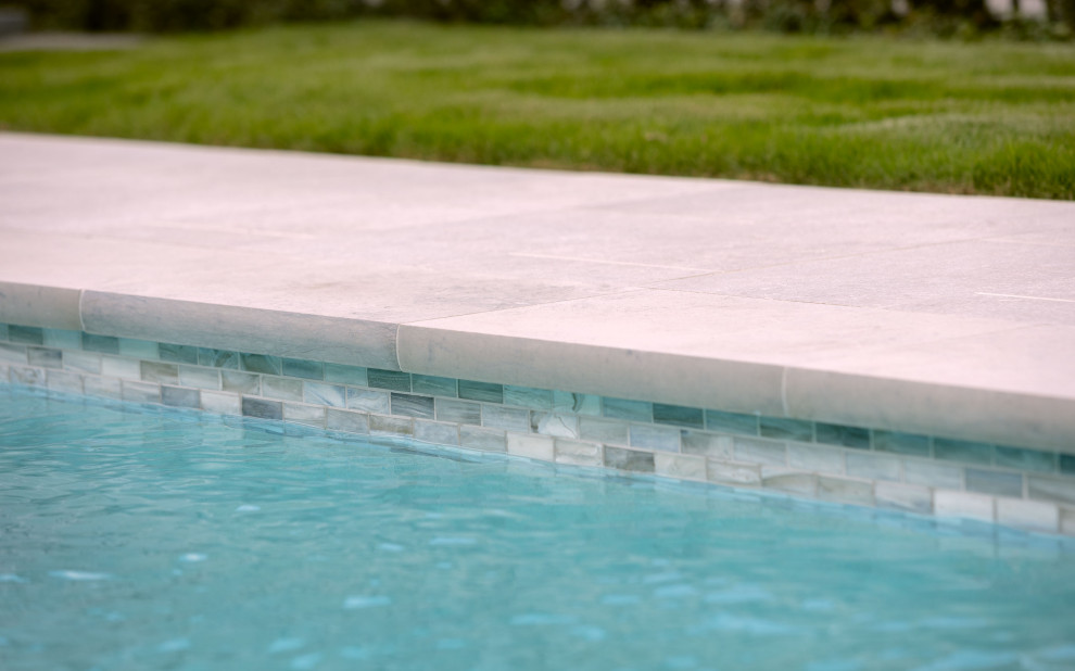 Exemple d'une piscine arrière chic de taille moyenne et rectangle avec des pavés en pierre naturelle.