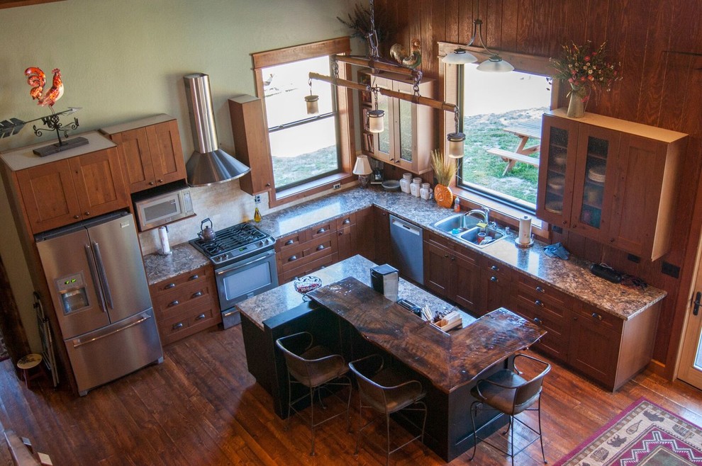 Example of a large arts and crafts l-shaped dark wood floor open concept kitchen design with a double-bowl sink, shaker cabinets, medium tone wood cabinets, granite countertops, stainless steel appliances and an island