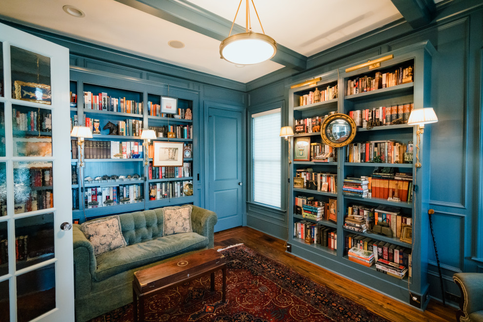 Immagine di un ufficio tradizionale di medie dimensioni con pareti blu, pavimento in legno massello medio, scrivania autoportante, pavimento marrone e pareti in legno